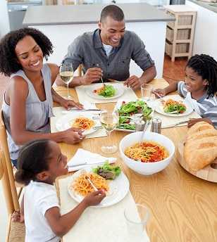 A family eating dinner together at the table.