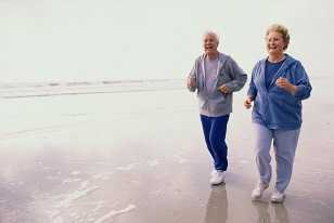 Elderly couple jogging on the beach.