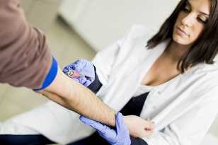 Man getting his blood drawn to check cholesterol levels. 