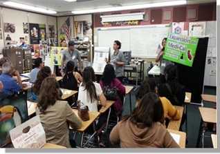 CHWs talking to people in a classroom environment.