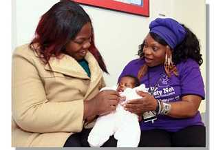 A CHW talking to a woman holding her baby.