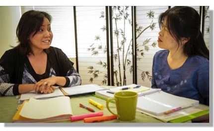 Two CHWs talking at a conference table.