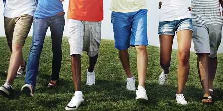 Image of six people walking with focus on their legs and feet