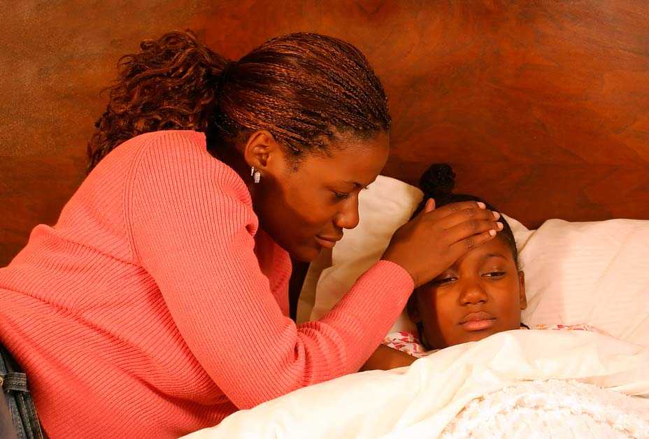 Mom checking daughter's forehead