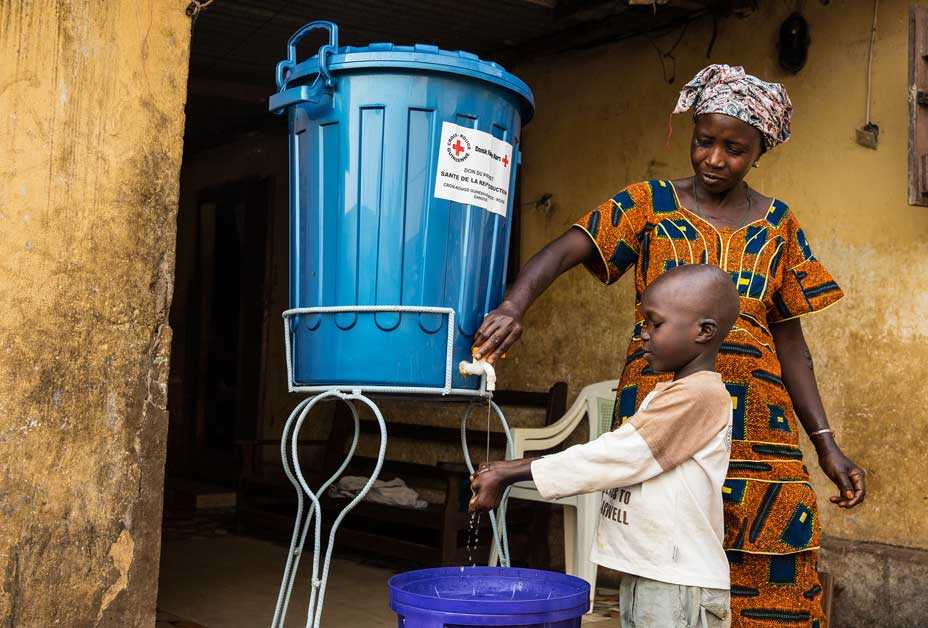 Mother washing child's hand with chlorine-treated water