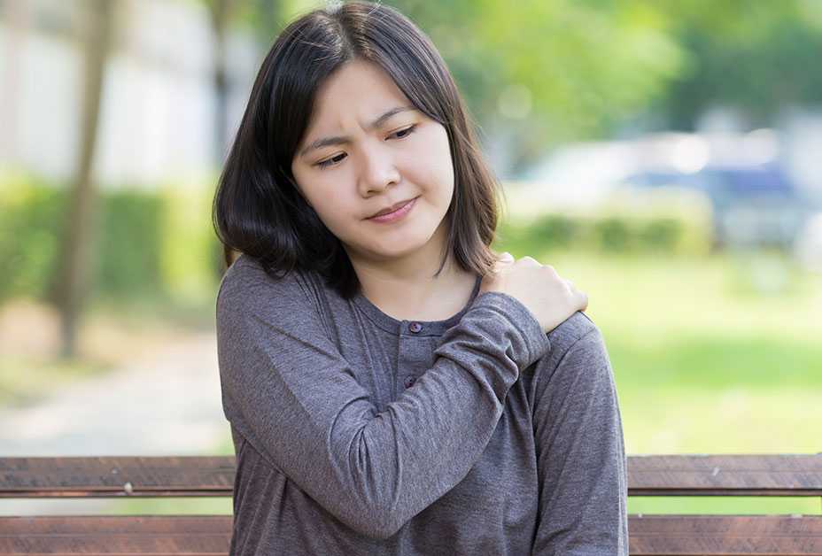 Woman holding sore shoulder