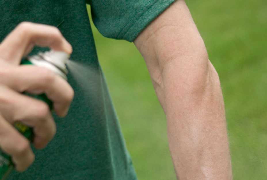 Man spraying insect repellent