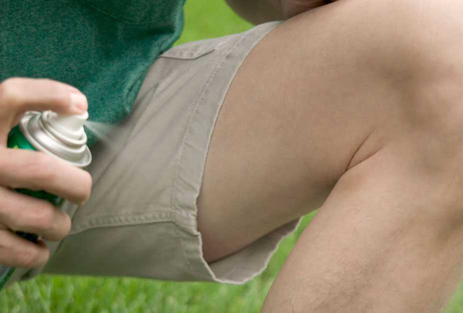 Man spraying insect repellent