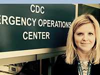Molly Fitch standing in front of CDC Emergency Operations Center Sign