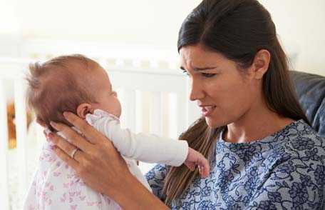 Frustrated mother holding baby