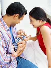 Photo: Parents holding a newborne.