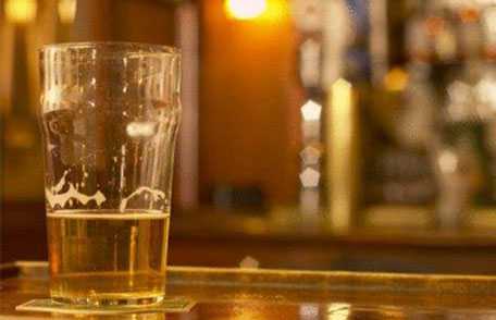 Glass of beer sitting on bar