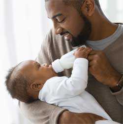 Father feeding baby bottle