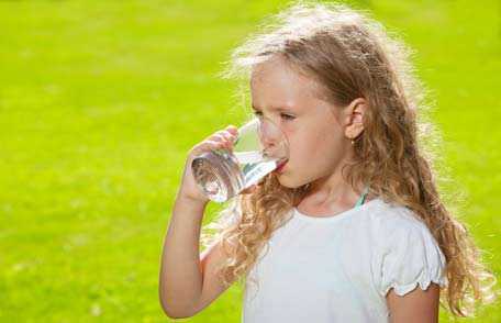 Young girl drinking glass of water