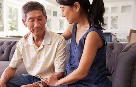 Adult woman consoling mature father