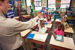 Students in classroom, raising hands