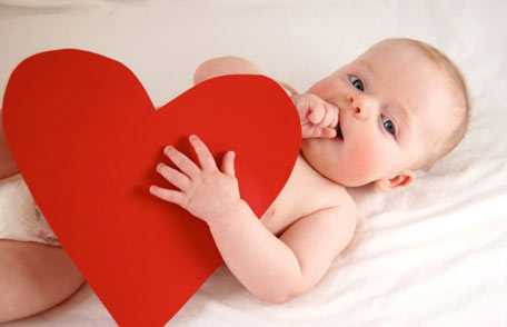 Baby holding paper heart