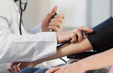 Doctor taking woman's blood pressure