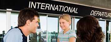 Photo: Young couple at international departure gate of airport.