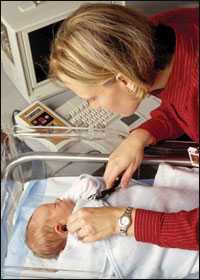 Photo: A woman checking a newborn's hearing