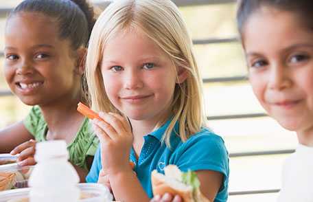 Students eating lunch together in school cafeteria
