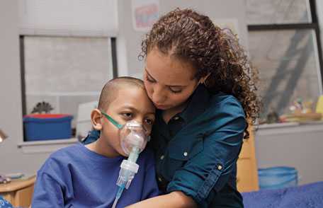 Jessica with her son, who is wearing an oxygen mask