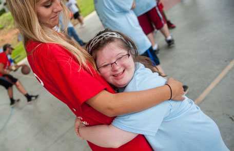 Special Olympics athlete hugging woman