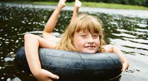 Young girl floating on tube in lake