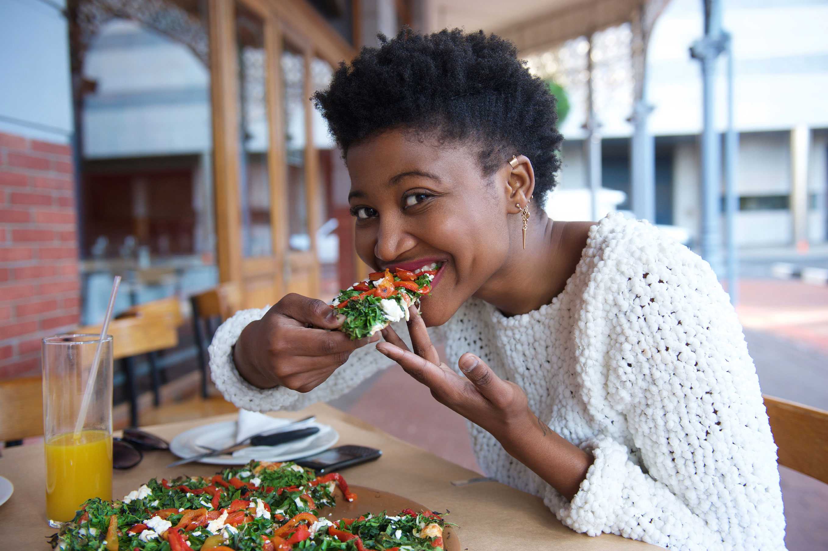Young woman eating vegetarian pizza