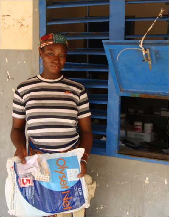 Woman holding bednet package in Benin