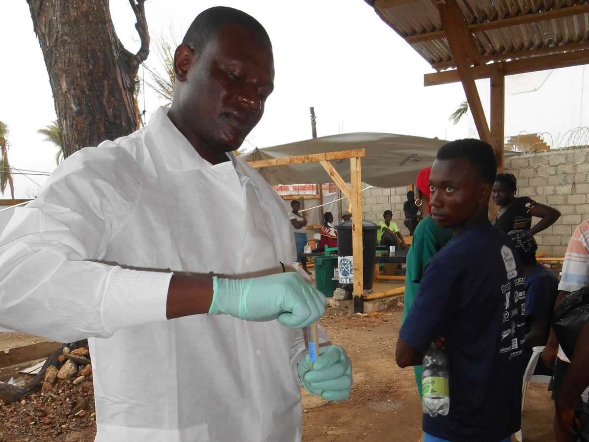 Jean Robert, FETP resident, performing rapid diagnostic testing for cholera at a cholera treatment center in Jeremie commune, Grande Anse Department, Haiti