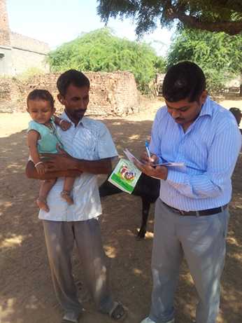 	Division coordinator checking village vaccination status for feedback to auxiliary nurse-midwife. Photo courtesy of Alice Pope, CDC.