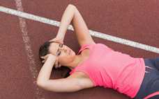 Female lying on track holding her head