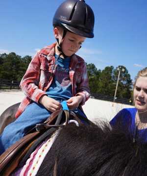 Boy being placed on a horse