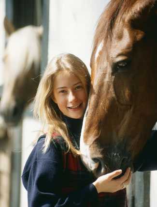 Horse nuzzles girl's hand