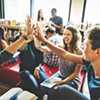 Teenagers in classroom giving high fives