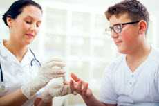 Healthcare worker taking blood from patient's finger