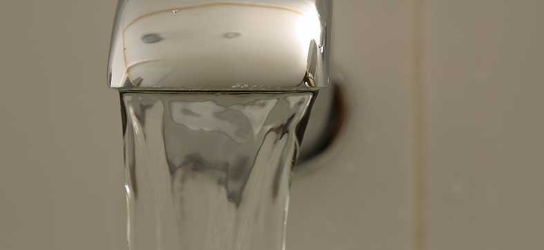 a stream of water coming out of an indoor faucet