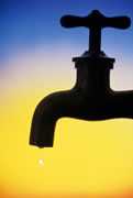 	A water faucet, silhouetted against the horizon