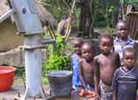 Children posed beside well.