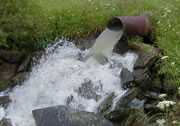 	Photo of wastewater coming from a pipe and out into a stream