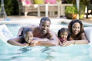 family swimming in pool