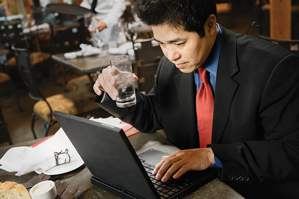 photo of a man working on a laptop in a cafe