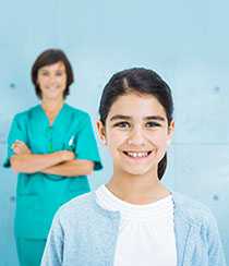 Healthcare provider standing behind a girl.