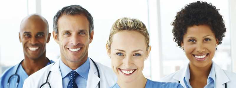 Portrait of successful doctors standing together and smiling 