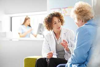 Healthcare worker talking to an elderly women about her pills