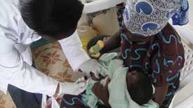 Nurse Dinah Mauti Maragwa gives malaria candidate vaccine to an infant at the Siaya KEMRI/CDC Malaria Vaccine Trial Site in Kenya. Courtesy: Alice Onsase and Kevin Shikanga, KEMRI/CDC