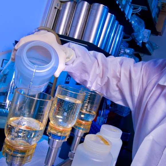 A CDC microbiologist pours water samples from a building experiencing a Legionnaires’ disease outbreak into a filtration system to test for Legionella.