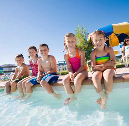 Kids sitting on the edge of a pool