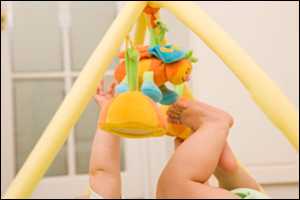 A baby playing with a baby gym